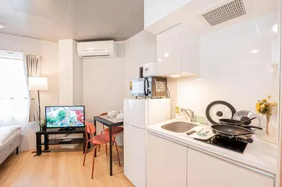 a small white kitchen with a sink and a desk at japan house T-Plaza sugamo in Tokyo