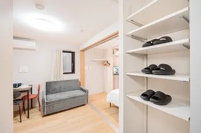 a room with a chair and a desk with a table at japan house T-Plaza sugamo in Tokyo