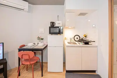 a small kitchen with a white refrigerator and a table at japan house T-Plaza sugamo in Tokyo