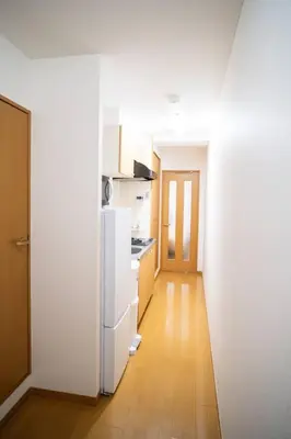 a kitchen with a white refrigerator and a wooden floor at \u65b0\u5c0f\u5ca9\u99c5\u5f92\u6b693\u5206\u30c7\u30e1\u30c6\u30eb301 in Tokyo