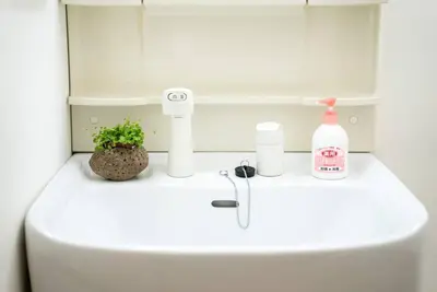 a white sink with a bottle of soap and a plant at \u65b0\u5c0f\u5ca9\u99c5\u5f92\u6b693\u5206\u30c7\u30e1\u30c6\u30eb301 in Tokyo