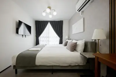 a bedroom with a large bed and a window at \u30eb\u30c1\u30eb\u6c60\u888b\u6771\u4eac in Tokyo