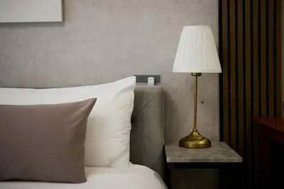 a hotel room with a bed with a lamp on a table at \u30eb\u30c1\u30eb\u6c60\u888b\u6771\u4eac in Tokyo