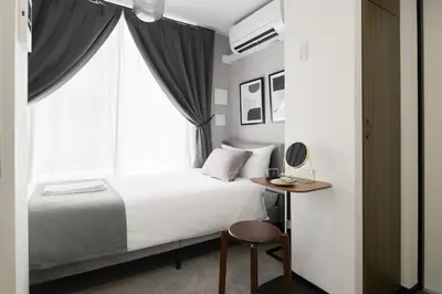 a bedroom with a bed and a table and a window at \u30eb\u30c1\u30eb\u6c60\u888b\u6771\u4eac in Tokyo