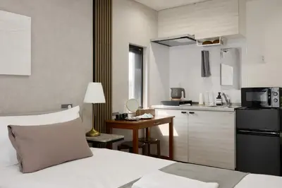 a bedroom with a bed and a small kitchen at \u30eb\u30c1\u30eb\u6c60\u888b\u6771\u4eac in Tokyo
