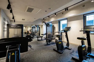 a gym with several treadmills and machines in a room at Section L Shimbashi West in Tokyo