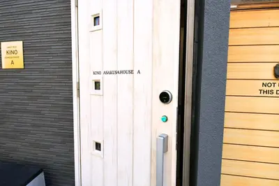 a door with a sign on it next to a building at 1棟貸切 宮元 みやげん in 浅草&雷門 - Miyagen in Asakusa&Kaminarimon- 浅草駅徒歩4分 上野や秋葉原までアクセス良好 最大16名 in Tokyo