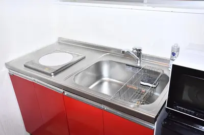 a kitchen sink with a dish drying rack next to a microwave at 1棟貸切 宮元 みやげん in 浅草&雷門 - Miyagen in Asakusa&Kaminarimon- 浅草駅徒歩4分 上野や秋葉原までアクセス良好 最大16名 in Tokyo