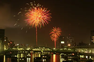 a firework display over a river with a city at 1棟貸切 宮元 みやげん in 浅草&雷門 - Miyagen in Asakusa&Kaminarimon- 浅草駅徒歩4分 上野や秋葉原までアクセス良好 最大16名 in Tokyo