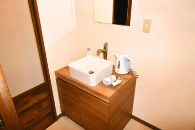 a bathroom with a white sink on a wooden counter at 1棟貸切 宮元 みやげん in 浅草&雷門 - Miyagen in Asakusa&Kaminarimon- 浅草駅徒歩4分 上野や秋葉原までアクセス良好 最大16名 in Tokyo