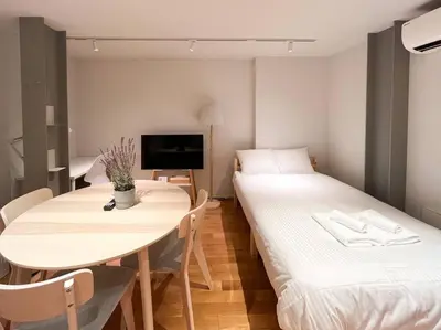 a room with two beds and a table and a tv at \u30a2\u30f3\u30c9\u30b9\u30c6\u30a4\u6771\u5411\u5cf66\u4e01\u76ee302 Soi house in Tokyo