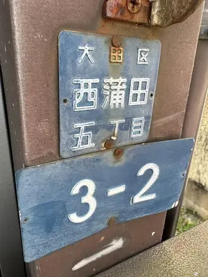 a blue parking meter with chinese writing on it at West Kamata 5 \u897f\u84b2\u672c\u5bb6 in Tokyo