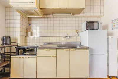 a kitchen with white cabinets and a white refrigerator at \u7acb\u77f35\u4e01\u76eem201 in Tokyo