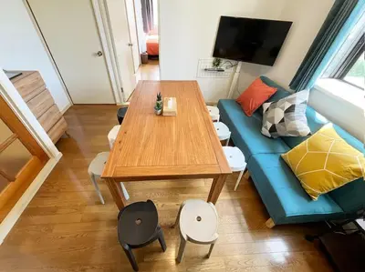a living room with a table and a blue couch at \u7acb\u77f35\u4e01\u76eem201 in Tokyo