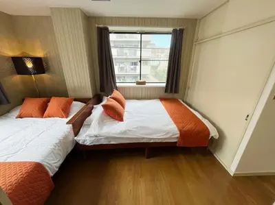 two beds in a room with a window at \u7acb\u77f35\u4e01\u76eem201 in Tokyo