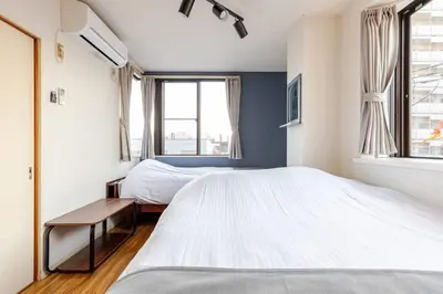a bedroom with two beds and a window at \u7acb\u77f35\u4e01\u76eem401 in Tokyo