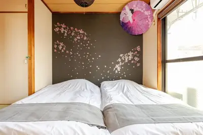 two beds in a bedroom with a wall with flowers at \u7acb\u77f35\u4e01\u76eem401 in Tokyo