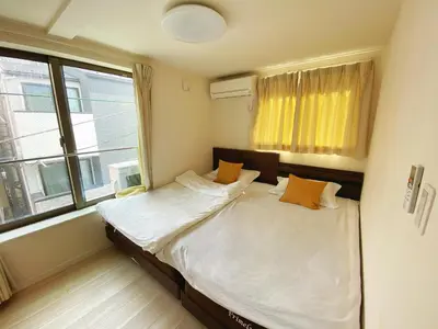 a bed in a room with a large window at \u4ec1\u6e90\u5bbf in Tokyo