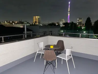 a table and chairs on a rooftop at night at \u4ec1\u6e90\u5bbf in Tokyo