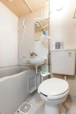 a white bathroom with a toilet and a sink at \u5f25\u751f\u753a1\u4e01\u76ee202 in Tokyo