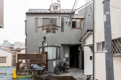 a building with two bikes parked outside of it at \u5f25\u751f\u753a1\u4e01\u76ee202 in Tokyo