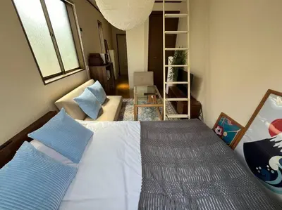 a bedroom with a white bed with blue pillows at \u5f25\u751f\u753a1\u4e01\u76ee206 in Tokyo