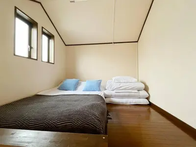 a bedroom with two beds and two windows at \u5f25\u751f\u753a1\u4e01\u76ee206 in Tokyo