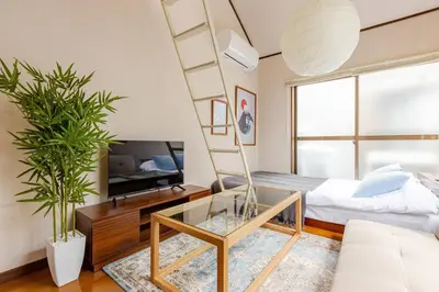 a living room with a ladder and a glass table at \u5f25\u751f\u753a1\u4e01\u76ee206 in Tokyo