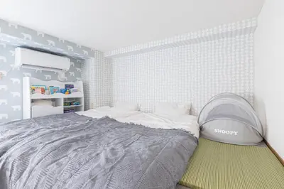 a bedroom with a bed with a gray comforter at Spacious 1120feet , 3-Bedroom Apartment near Ikebukuro, 2 Minutes to Train in Tokyo