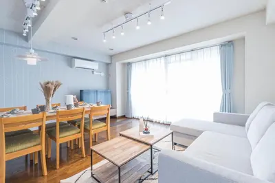a living room with a dining room table and a couch at Spacious 1120feet , 3-Bedroom Apartment near Ikebukuro, 2 Minutes to Train in Tokyo