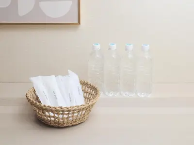 three bottles of water and a basket on a table at tokyo Japandi apartment ikebukuro in Tokyo