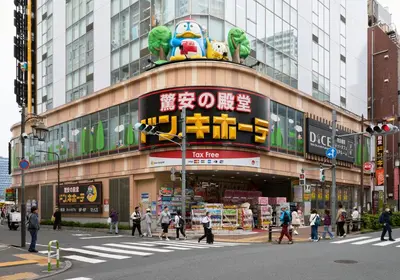 a busy city street with people crossing the street in front of a building at tokyo Japandi apartment ikebukuro in Tokyo