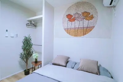 a bedroom with a bed and a painting on the wall at Sky Inn \u65b0\u7bc9\u72ec\u680b\u6238\u5efa \u65e5\u5f0f\u98ce\u773a\u671b\u5929\u7a7a\u6811 in Tokyo