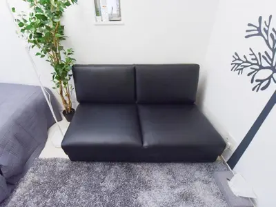 a black couch sitting in a room with plants at Sugamototate - Vacation STAY 50637v in Tokyo