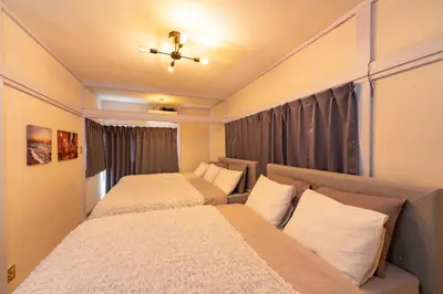 a bedroom with two beds and a couch at TK House Tokyo Ikebukuro Max5PPL in Tokyo