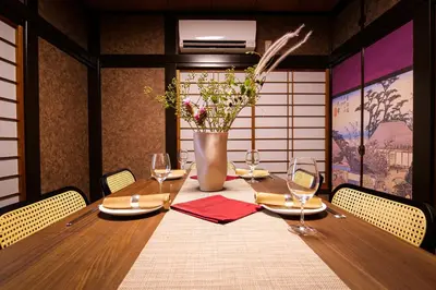 a table with chairs and a vase with flowers at Urayasu Villa in Tokyo