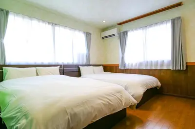 two beds in a room with two windows at Urayasu Villa in Tokyo