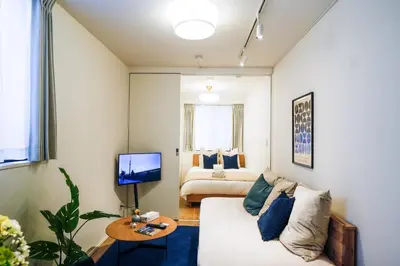 a living room with a couch and a bed at Fullea Yotsuya in Tokyo