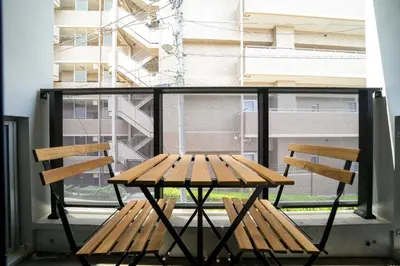 a wooden table and two chairs in front of a window at Fullea Yotsuya in Tokyo