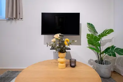 a yellow vase with flowers on top of a table at Fullea Yotsuya in Tokyo