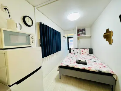 a small bedroom with a bed and a microwave at Real Waseda SJ0261 in Tokyo