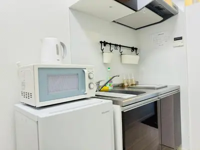 a white kitchen with a microwave and a sink at Real Waseda SJ0261 in Tokyo