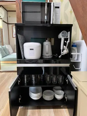 a black shelf with dishes and a microwave at \u5f25\u751f\u753a1\u4e01\u76ee\u6238\u5efa in Tokyo