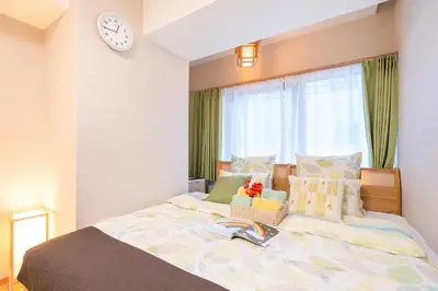 a bedroom with a bed with a clock on the wall at \u79cb\u53f6\u539f\u5609\u967d\u30d3\u30eb in Tokyo