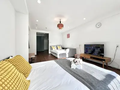 a bedroom with a white bed with two teddy bears on it at KKHouse in Tokyo