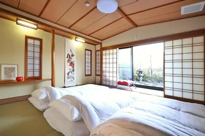 a bedroom with two beds in a room with a window at \u9326\u7cf8\u753a\u5f92\u6b694\u5206210\u5e73\u7c73\u5927\u7a7a\u9593\u548c\u98a8\u5ead\u5712\u30c6\u30e9\u30b9\u30b9\u30ab\u30a4\u30c4\u30ea\u30fc\u30d3\u30e5\u30fc\u7573\u90e8\u5c4b in Tokyo
