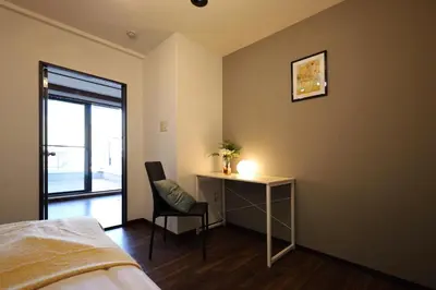 a bedroom with a desk and a chair with a lamp at \u9326\u7cf8\u753a\u5f92\u6b694\u5206210\u5e73\u7c73\u5927\u7a7a\u9593\u548c\u98a8\u5ead\u5712\u30c6\u30e9\u30b9\u30b9\u30ab\u30a4\u30c4\u30ea\u30fc\u30d3\u30e5\u30fc\u7573\u90e8\u5c4b in Tokyo