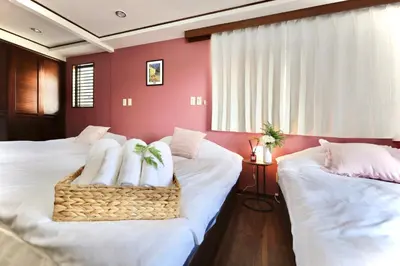two beds in a room with red walls at \u9326\u7cf8\u753a\u5f92\u6b694\u5206210\u5e73\u7c73\u5927\u7a7a\u9593\u548c\u98a8\u5ead\u5712\u30c6\u30e9\u30b9\u30b9\u30ab\u30a4\u30c4\u30ea\u30fc\u30d3\u30e5\u30fc\u7573\u90e8\u5c4b in Tokyo