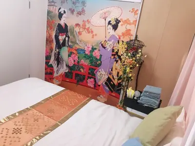a bedroom with a painting on the wall next to a bed at B & K Nakanosakaue in Tokyo