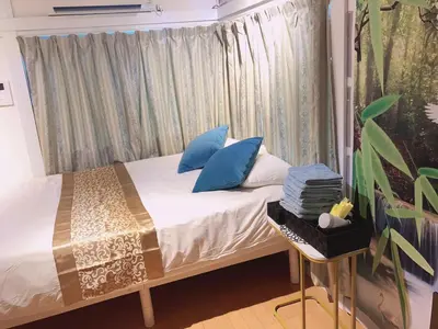 a bedroom with a bed with blue pillows at B & K Nakanosakaue in Tokyo